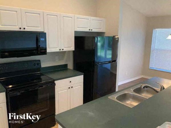 A kitchen with black appliances and white cabinets.