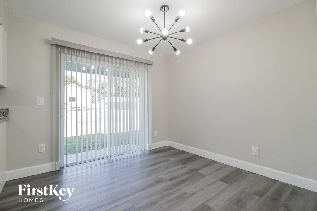 A well-lit room with a sliding glass door leading to a balcony.