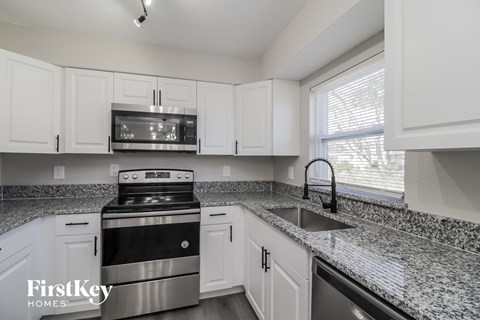 A kitchen with a stove top oven and a microwave above it.