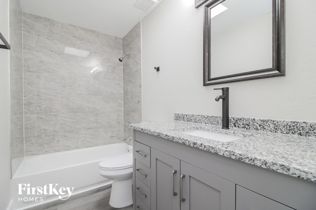 A bathroom with a marble countertop and a white toilet.
