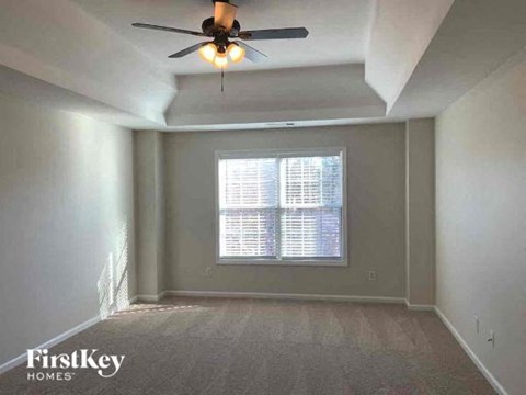 an empty room with a ceiling fan and a window