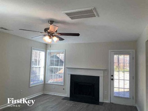 a living room with a ceiling fan and a fireplace