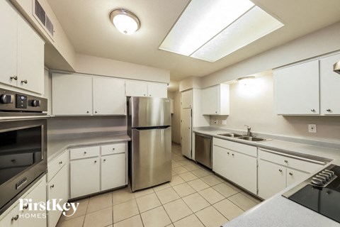 a large kitchen with stainless steel appliances and white cabinets