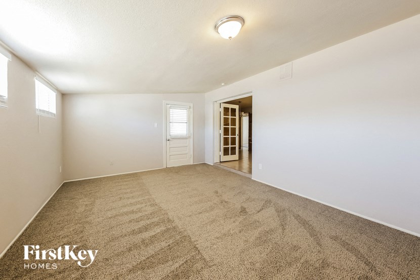 an empty living room with carpet and a door to a closet