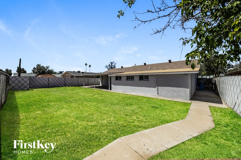 the backyard of a house with a lawn and a fence