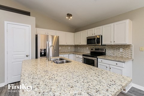 a kitchen with white cabinets and a granite counter top