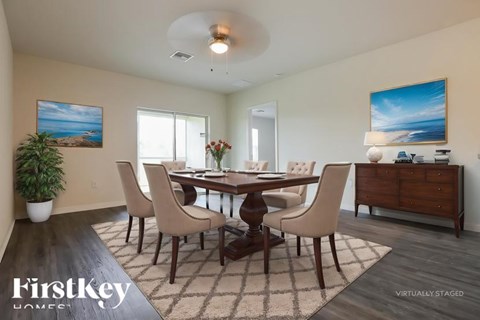 A dining room with a wooden table and chairs.