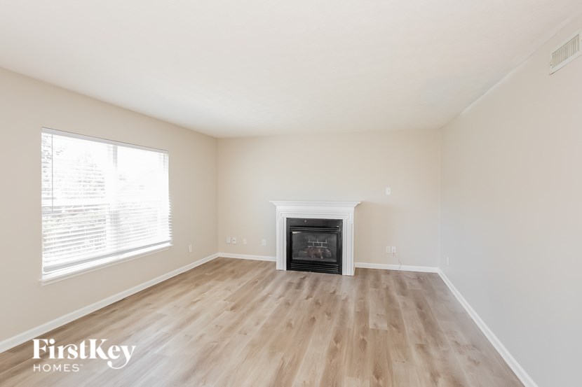 A room with a fireplace and wooden flooring.