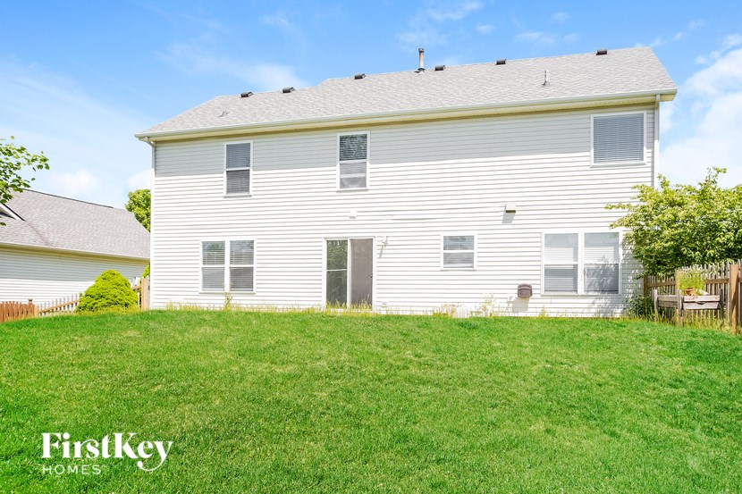 A white house with a green lawn in front of it.