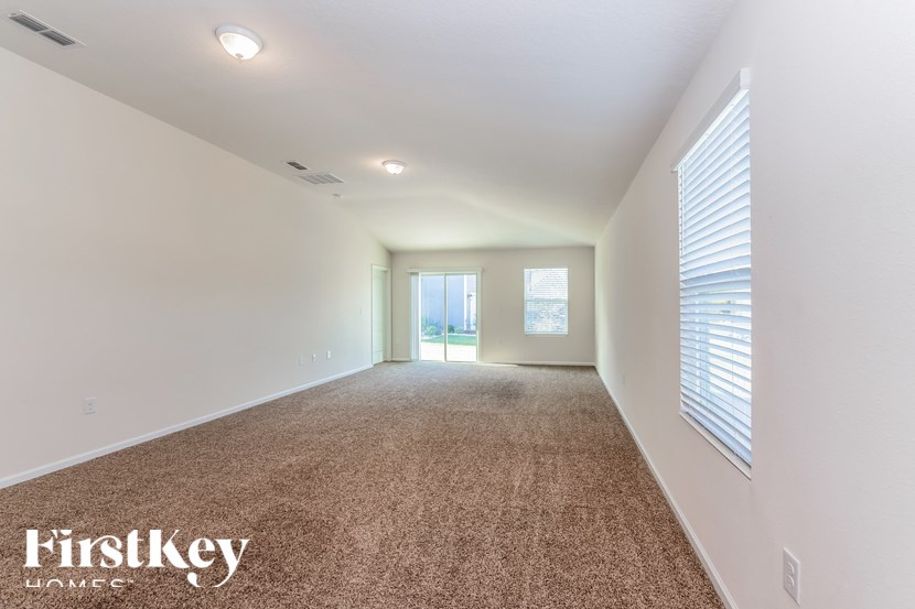 A spacious room with carpeted floor and white walls.