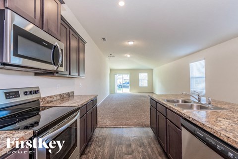 A kitchen with a stove top oven, microwave, and dishwasher.