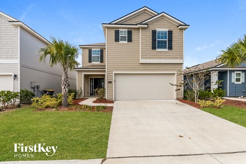 a beige house with a garage door and a driveway