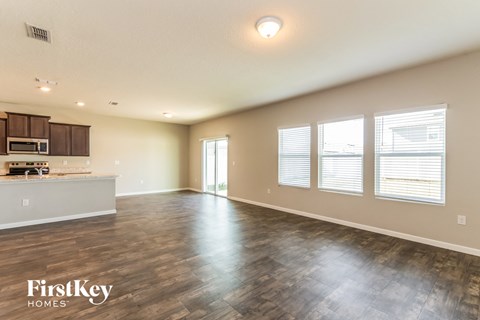 the living room and kitchen of an empty house