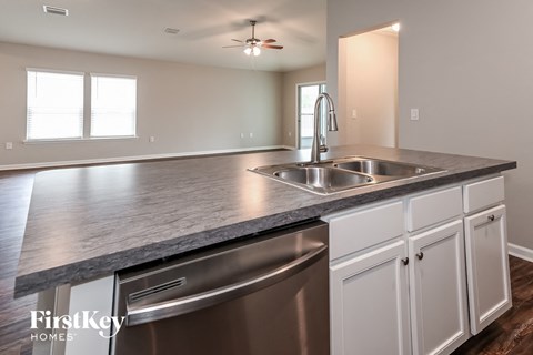 a kitchen with white cabinets and a stainless steel sink