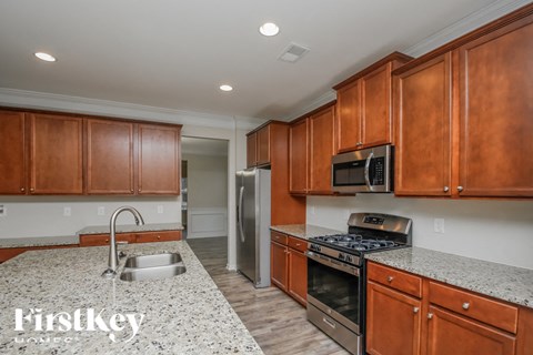 A kitchen with wooden cabinets and a granite countertop.