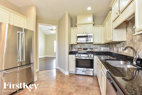 A kitchen with a stainless steel refrigerator and a stainless steel sink.