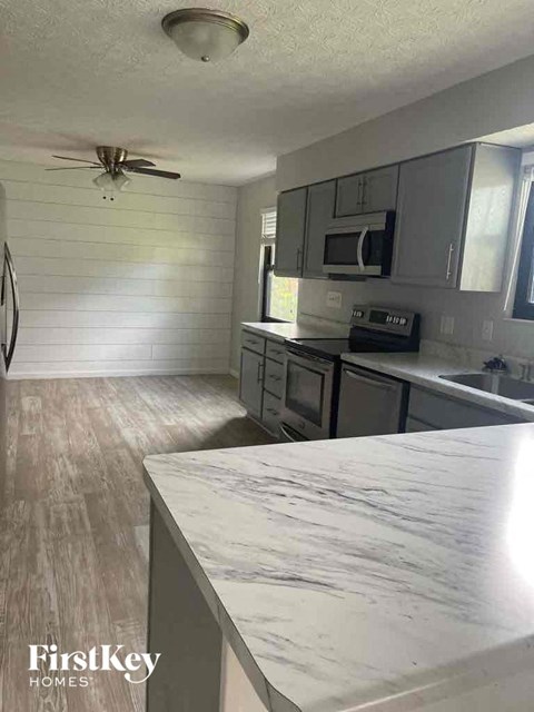 a kitchen with a marble counter top and stainless steel appliances