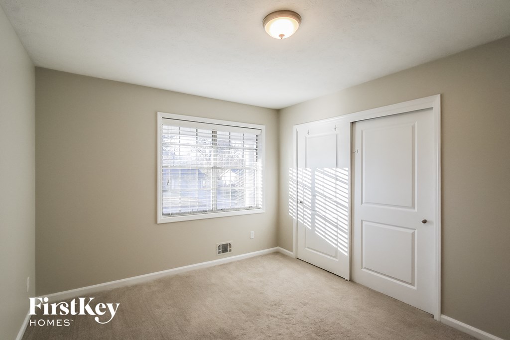 a bedroom with a large window and a white door