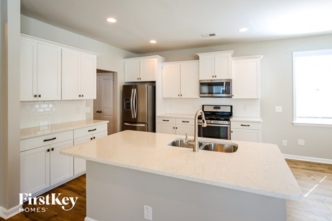 A kitchen with white cabinets and a large island.