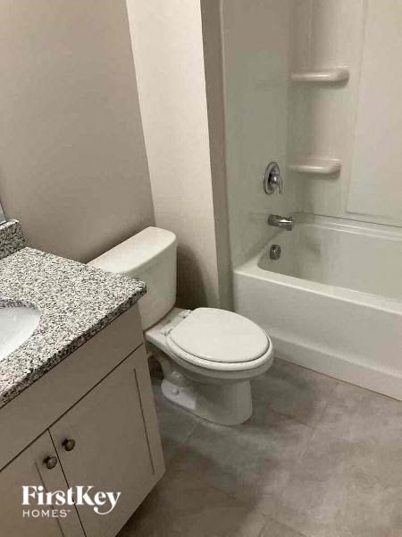 a bathroom with a toilet and a tub and a sink