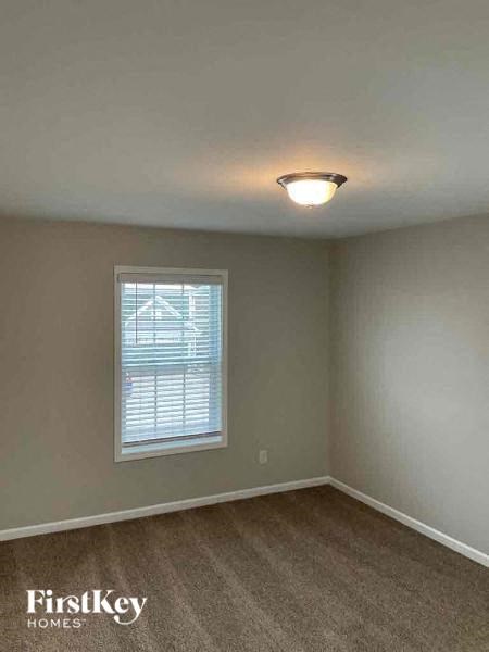an empty room with a window and a light on the ceiling