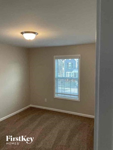 an empty room with a window and a light in it