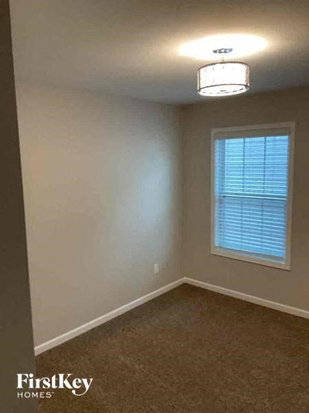 an empty room with a window and a ceiling light