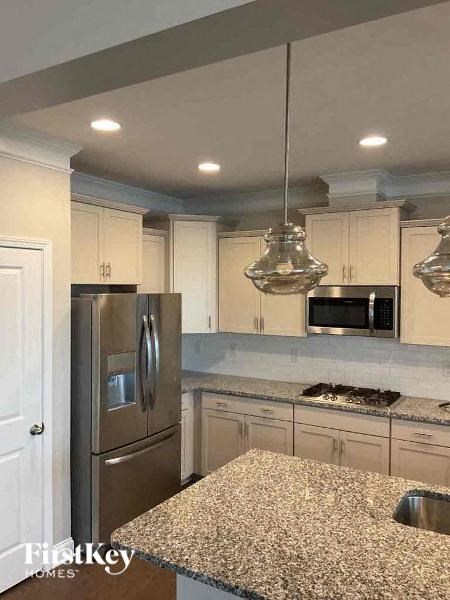 a kitchen with white cabinets and a stainless steel refrigerator