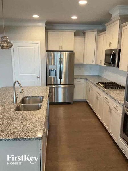 a kitchen with white cabinets and a stainless steel refrigerator