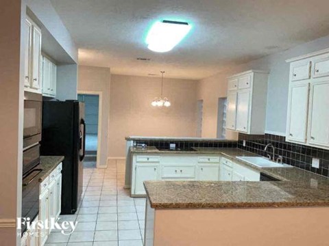 a kitchen with white cabinets and a counter top