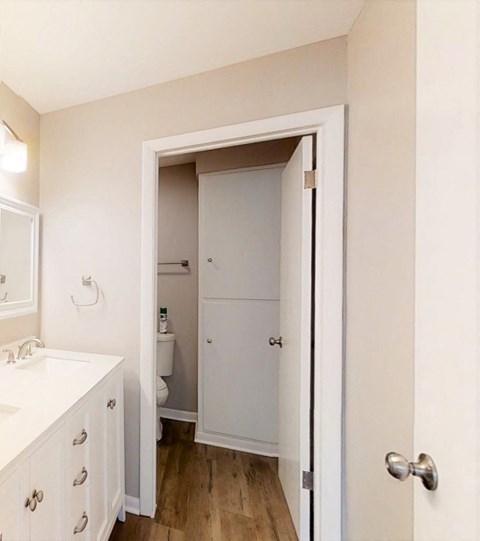 an empty bathroom with a door open to a closet