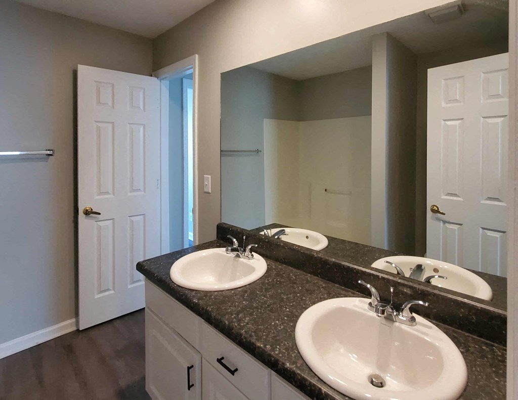 a bathroom with three sinks and a large mirror