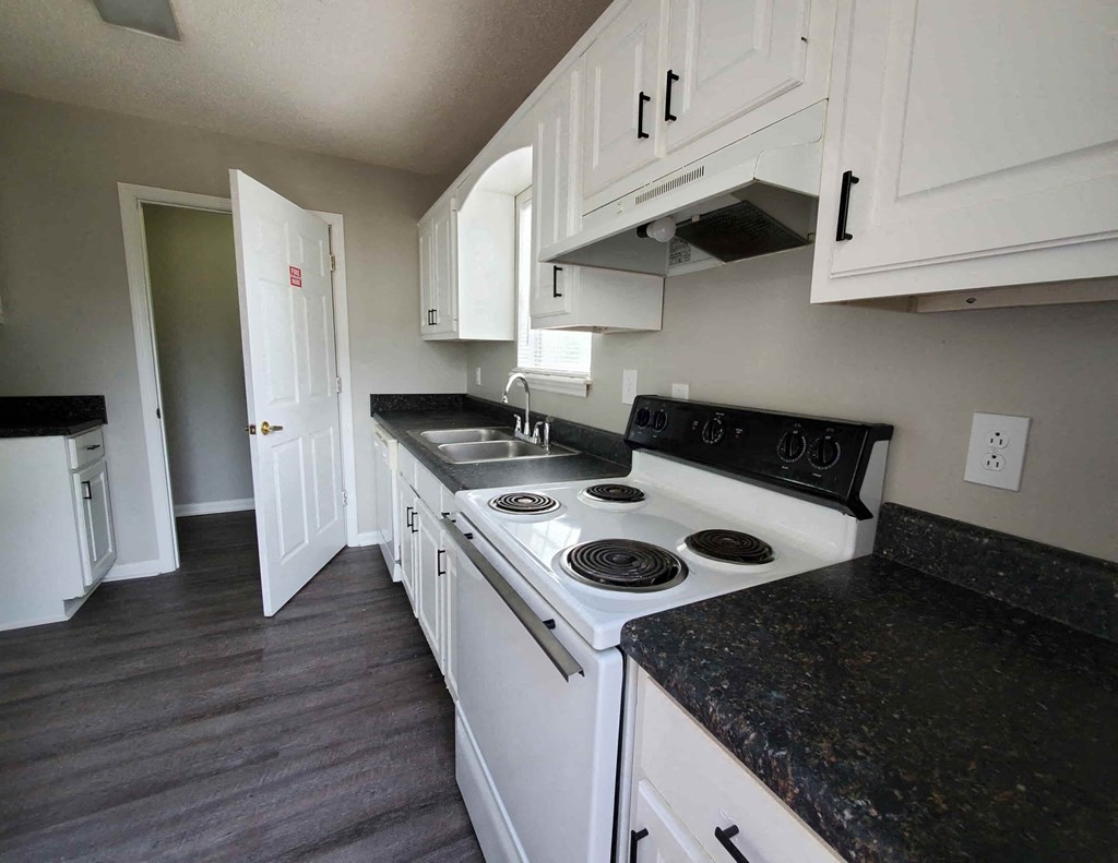 a kitchen with white appliances and black counter tops