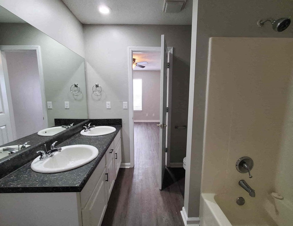 a bathroom with two sinks and a shower and a mirror