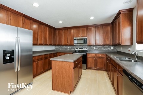 A kitchen with wooden cabinets and a stainless steel refrigerator.