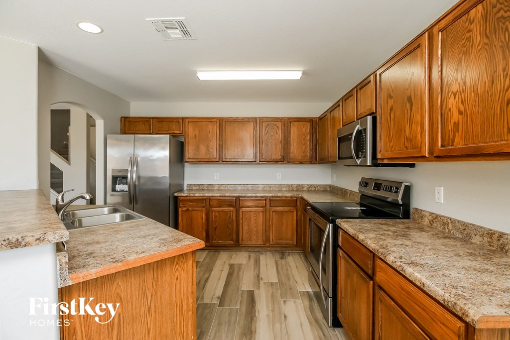A kitchen with wooden cabinets and granite countertops.