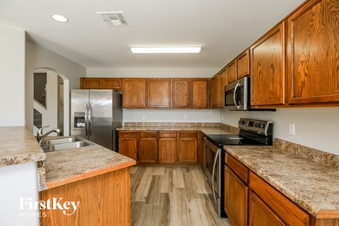 A kitchen with wooden cabinets and granite countertops.