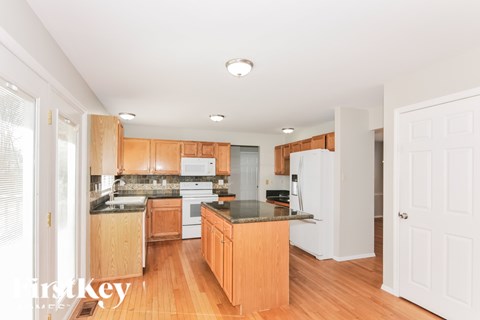 A kitchen with wooden cabinets and a white refrigerator.