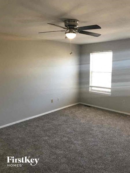an empty room with a ceiling fan and a window