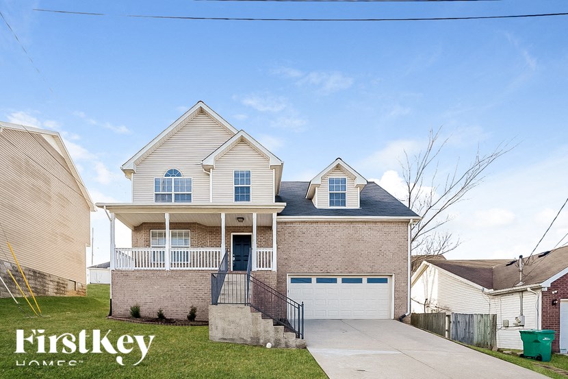 A house with a garage and a front porch is for sale.