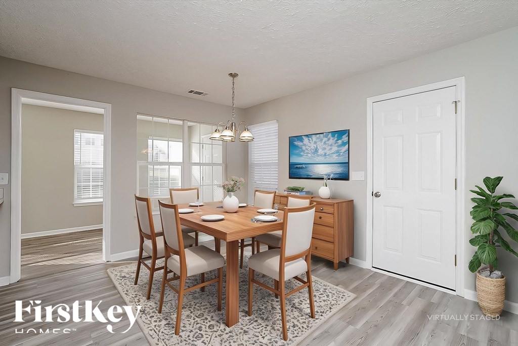 A dining room with a wooden table and chairs.