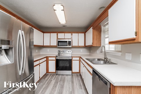 A kitchen with wooden cabinets and a stainless steel refrigerator.