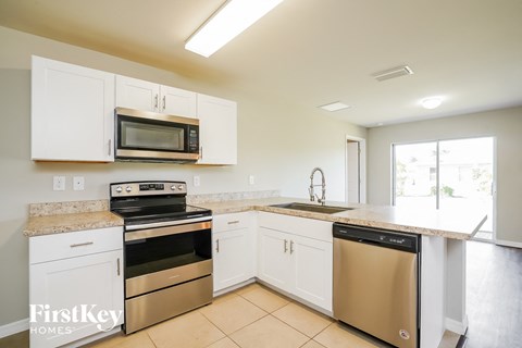 A kitchen with white cabinets and stainless steel appliances.