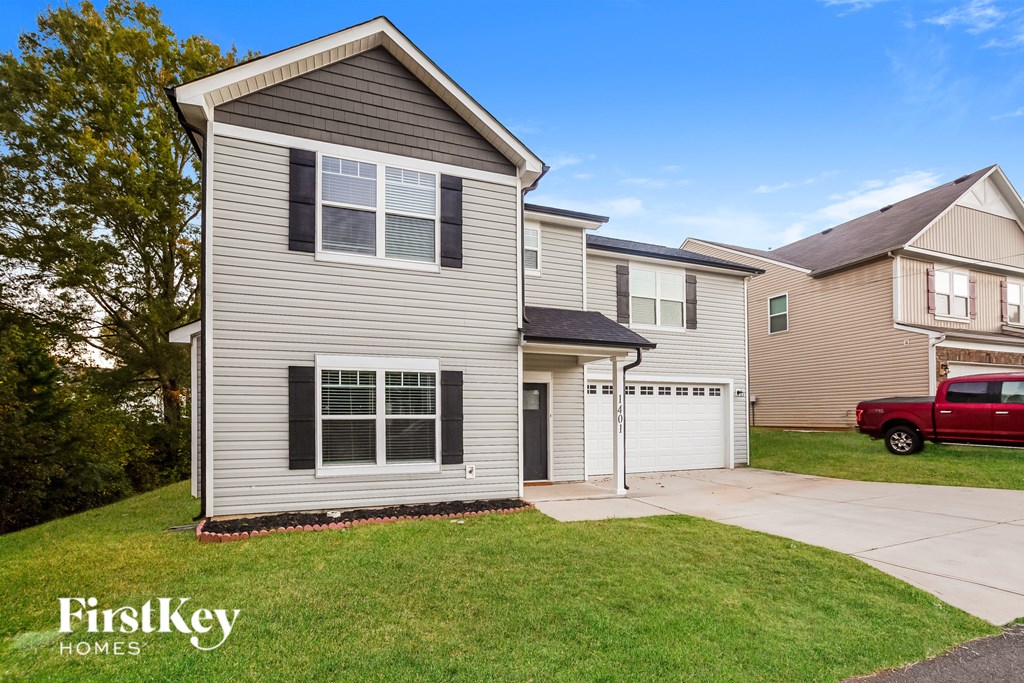 A house with a grey exterior and a red truck parked in the driveway.