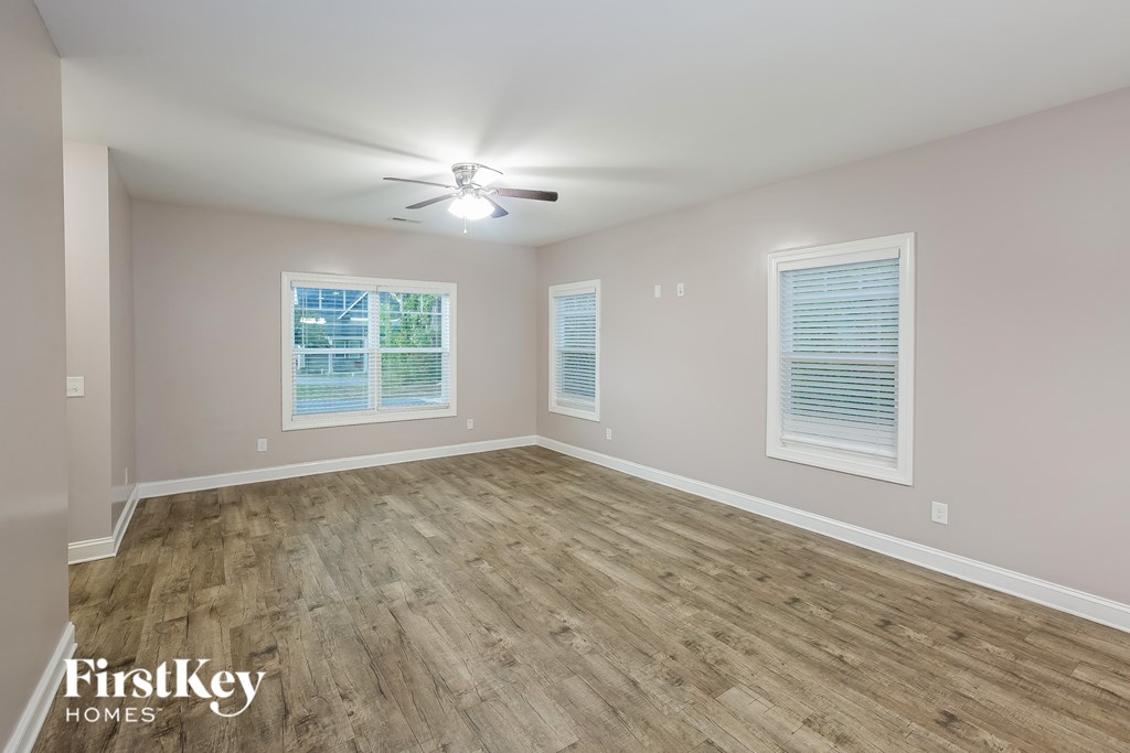 A room with wooden flooring and a ceiling fan.