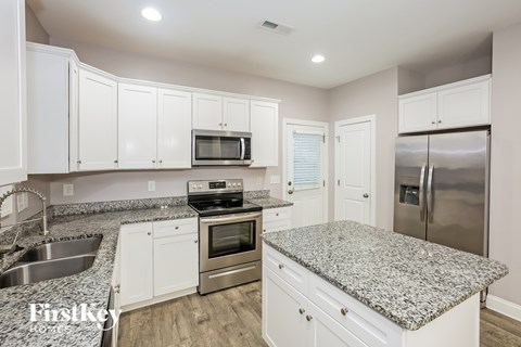 A kitchen with granite countertops and stainless steel appliances.