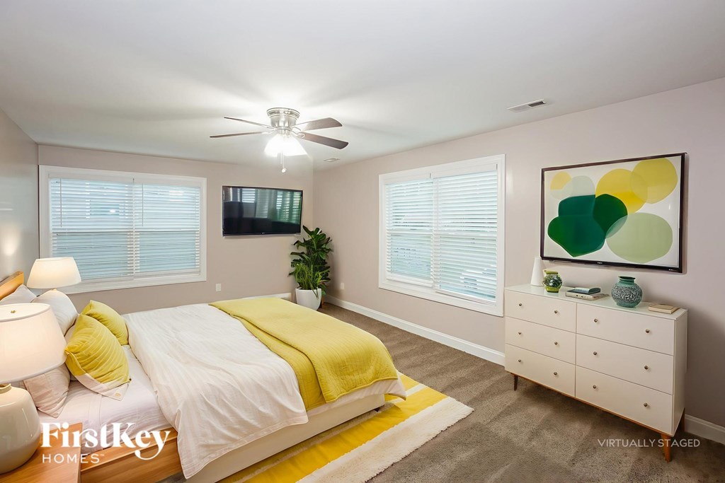 A bedroom with a bed, dresser, and a painting on the wall.
