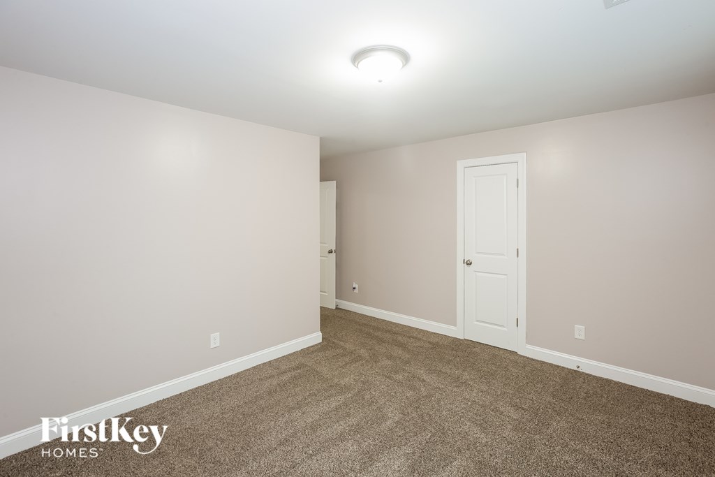 A room with a carpeted floor and a white door.