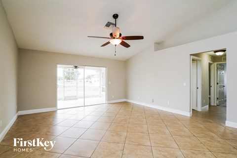 A spacious room with a ceiling fan and tiled flooring.