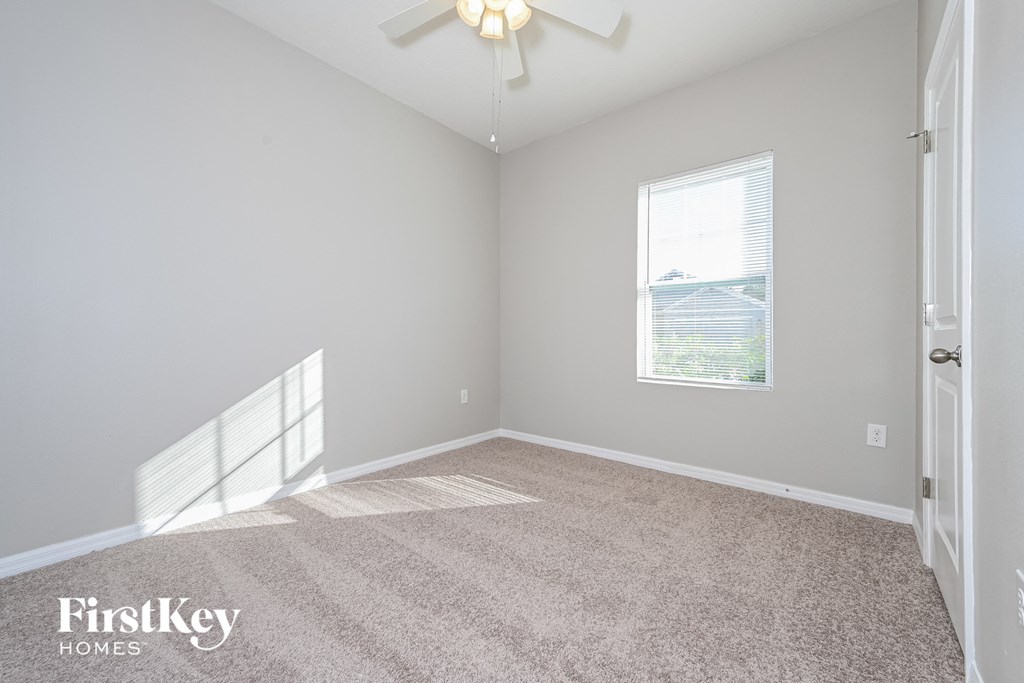 a bedroom with a carpeted floor and a ceiling fan